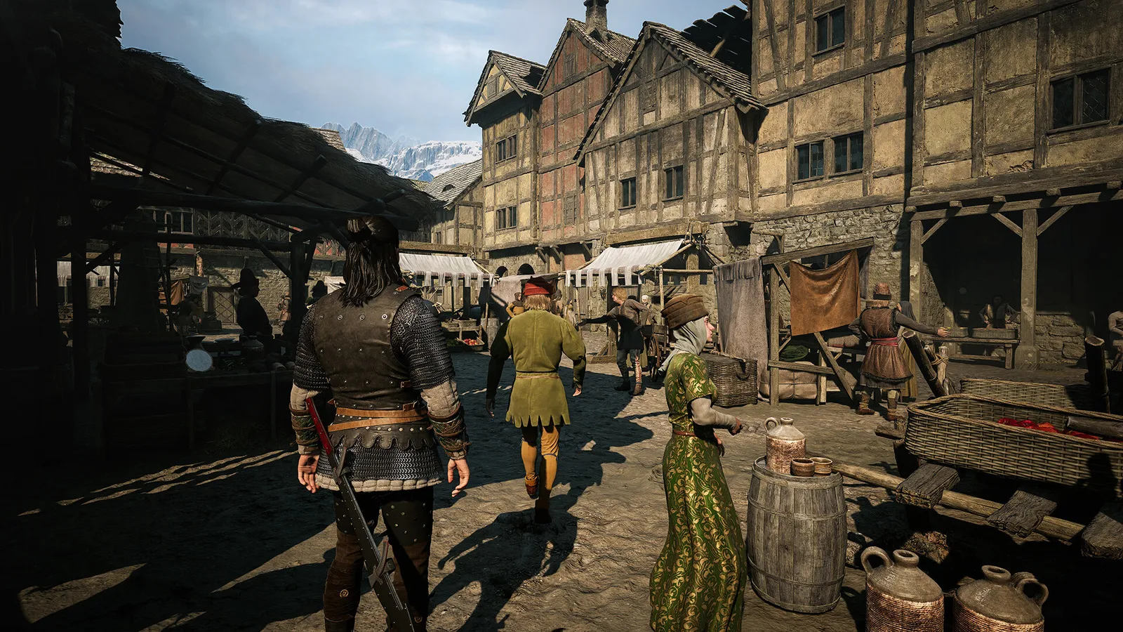 Personagem armado caminha por um mercado medieval, entre moradores, barris, bancas e casas de madeira e pedra.